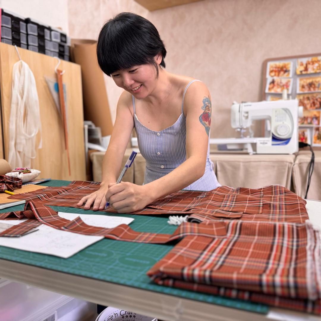 A student cutting fabric in the Cheras studio