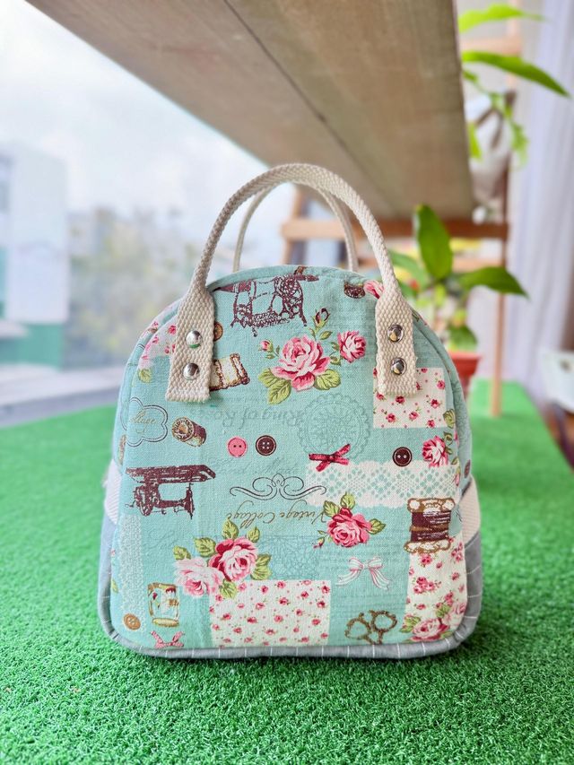 An insulated lunch bag sewn from mint floral fabric