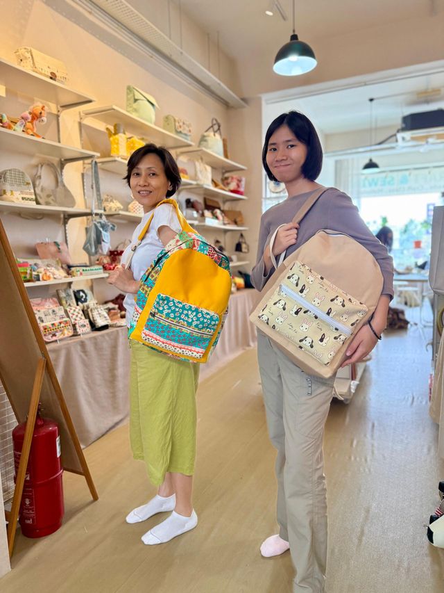 Two students each wearing a backpack they sewed